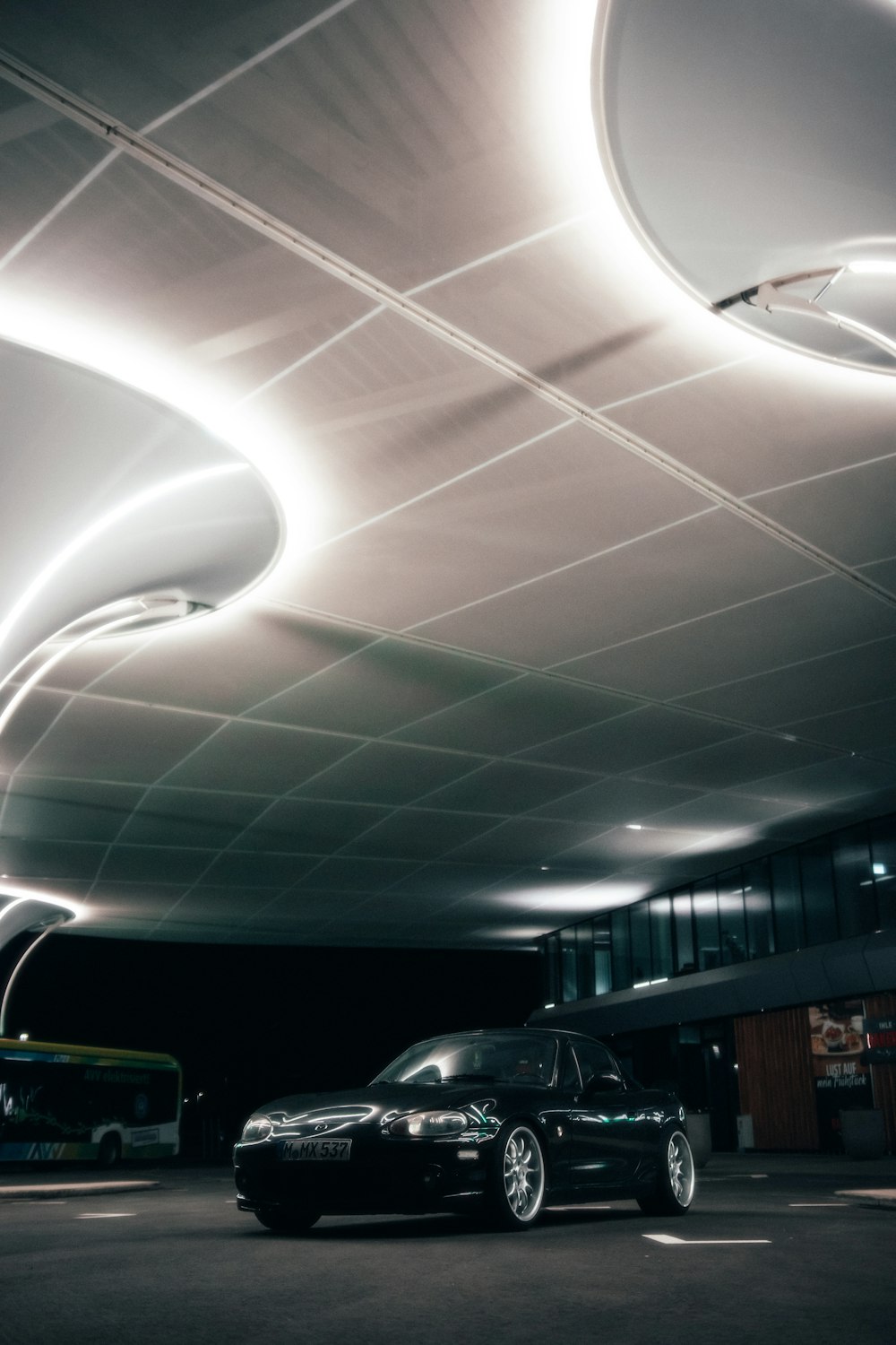 two cars parked in a parking lot under a ceiling