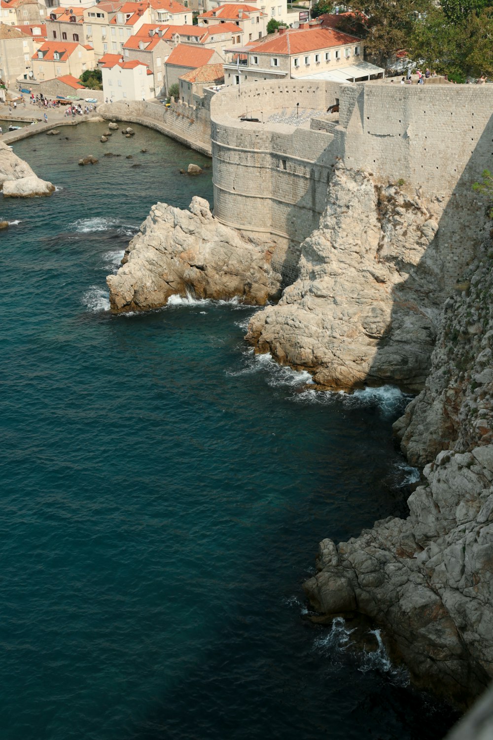 a large body of water next to a stone wall