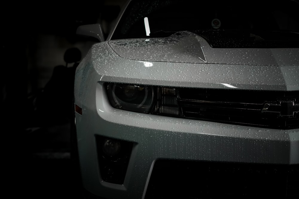 the front of a silver car in the dark