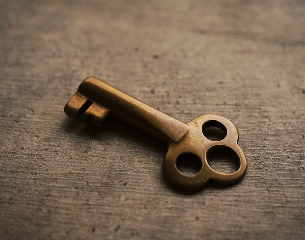 an old brass key on a wooden surface