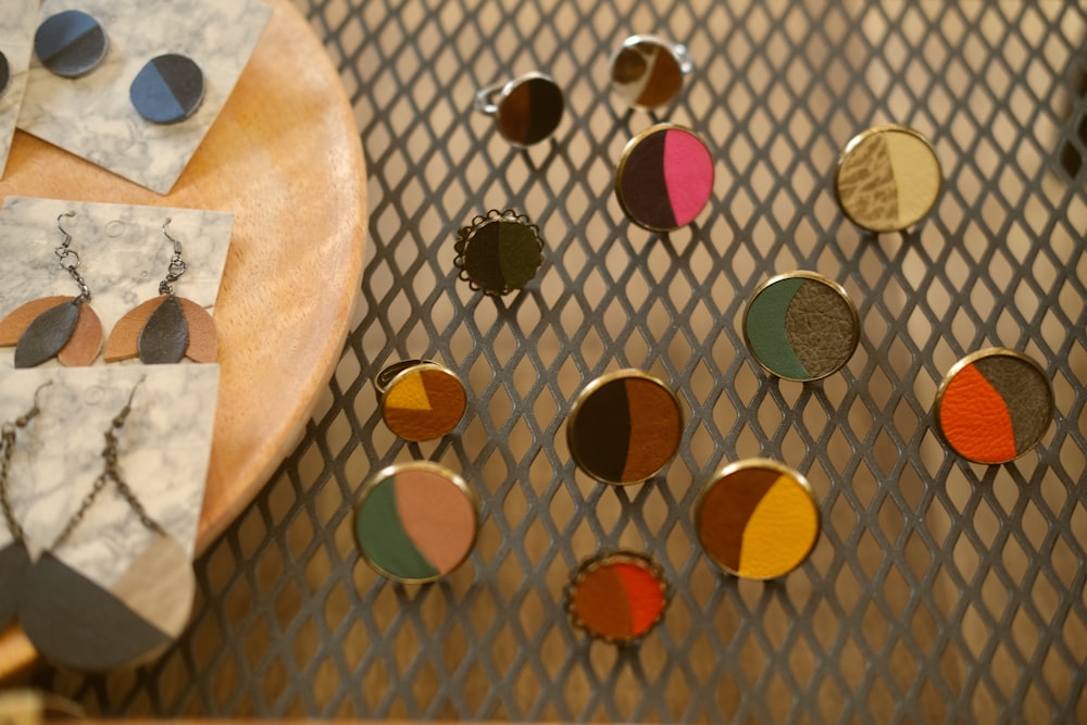 a table topped with lots of different colored earrings