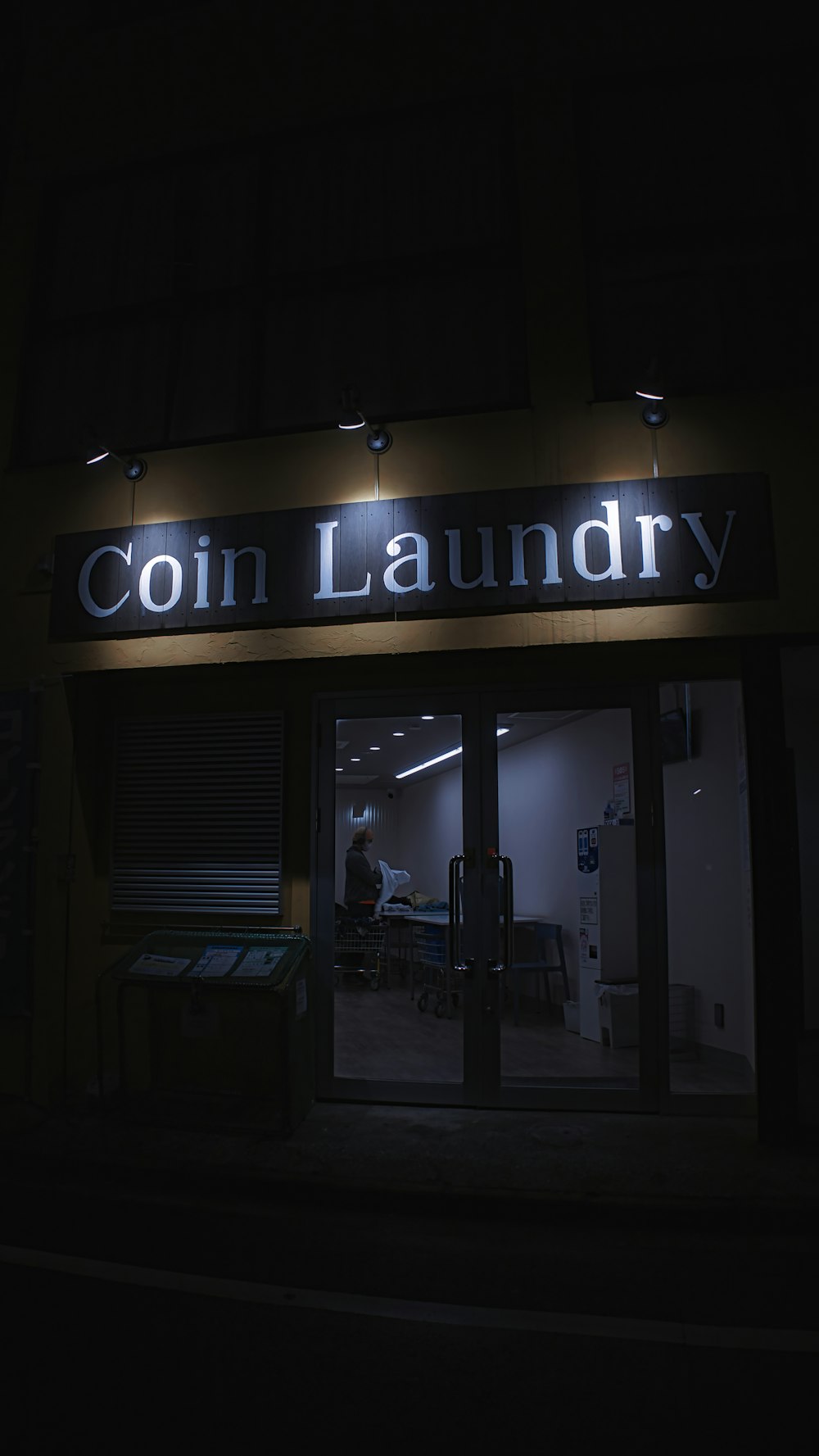 a sign that reads coin laundry lit up at night