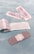 Several adhesive bandages and their packaging are placed on a light blue surface. The bandages are surrounded by opened and unopened wrappers that display the word 'BANDAGE' in red.