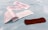 Several adhesive bandage strips are placed on a light blue surface. An open wrapper reveals one brown bandage strip, while other bandages are still wrapped.