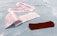 Several adhesive bandage strips are placed on a light blue surface. An open wrapper reveals one brown bandage strip, while other bandages are still wrapped.