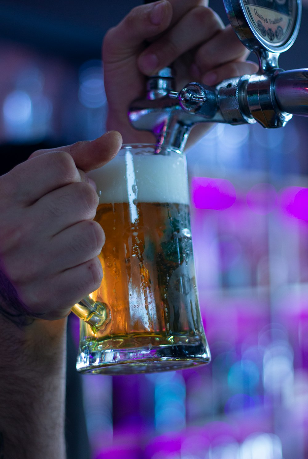 a close up of a person holding a glass of beer