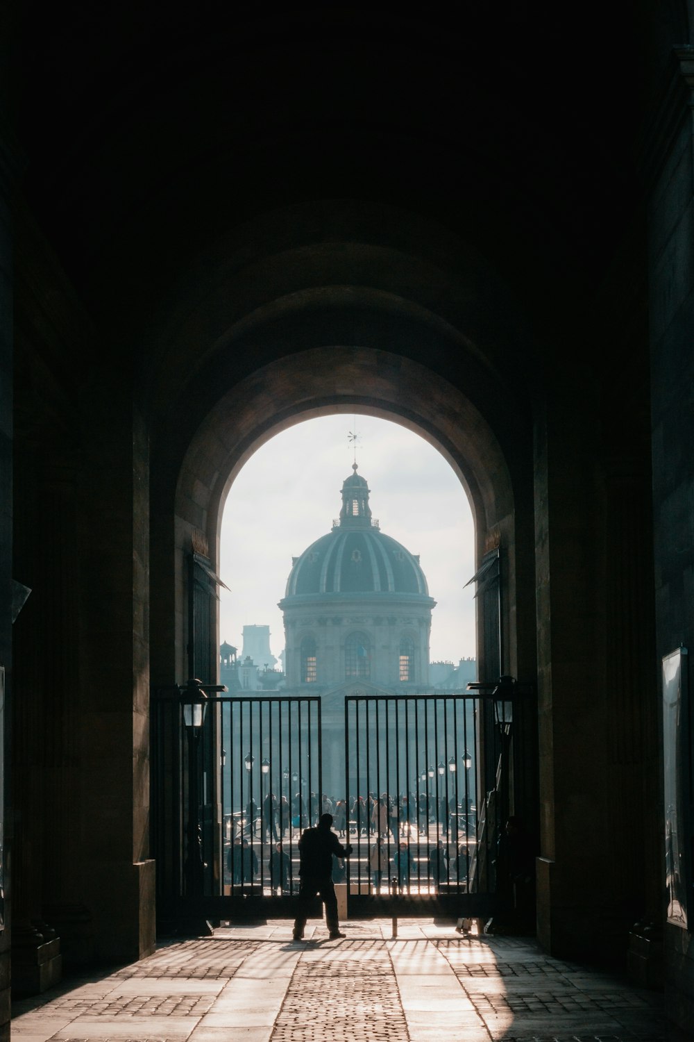 a person standing in an archway with a building in the background