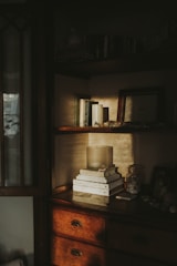 A collection of candles and soft textiles on a shelf.