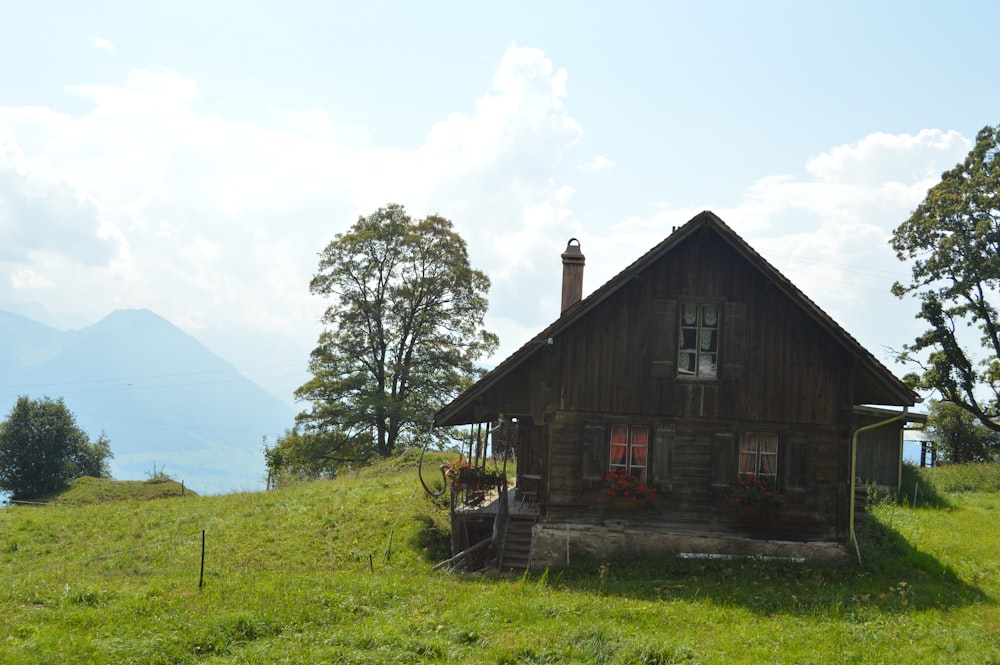 a small wooden house sitting on top of a lush green hillside