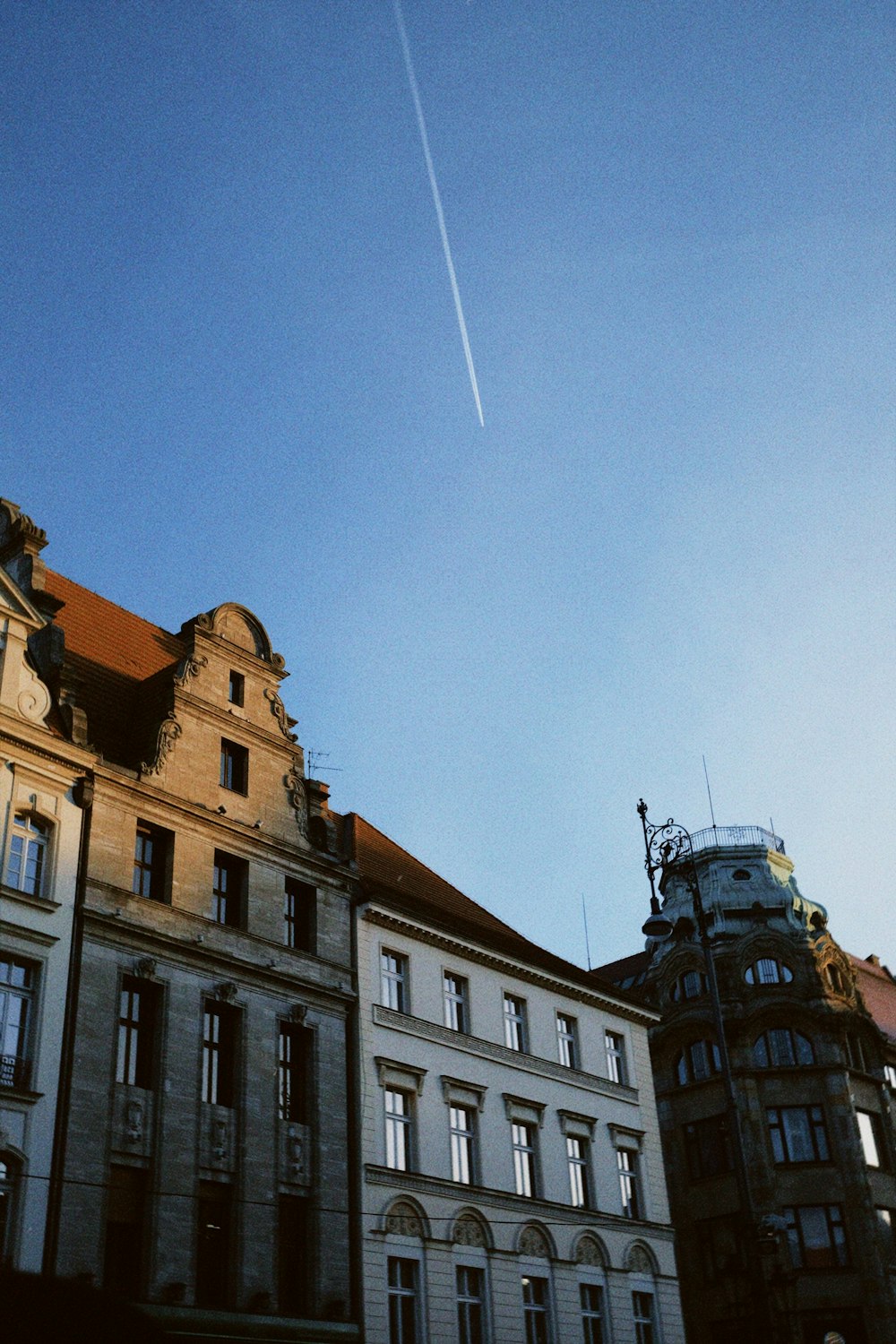 a plane flying over a building with a sky background