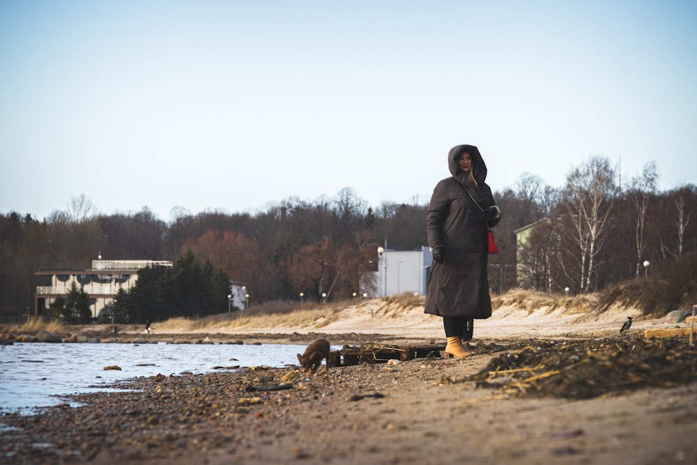 a person standing on a beach next to a body of water