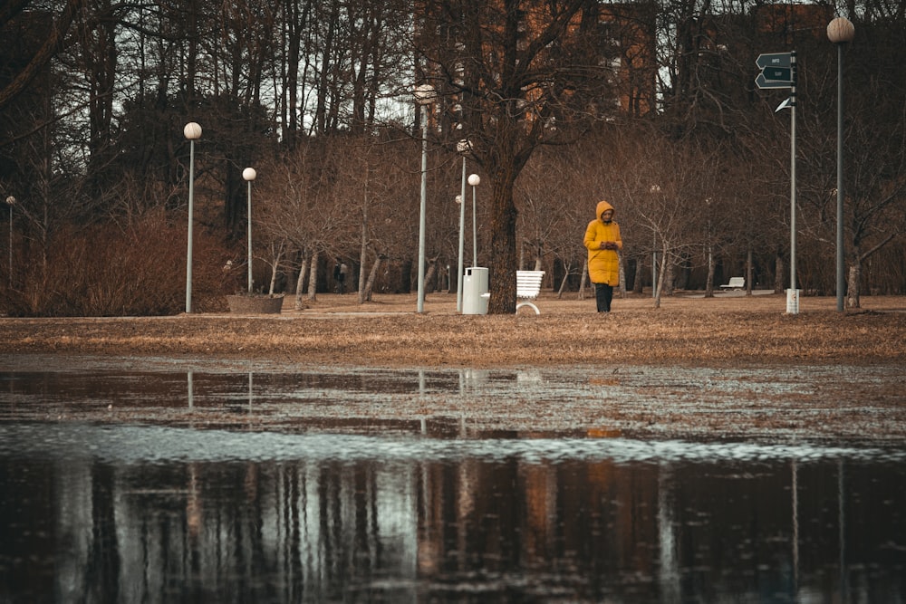 a person in a yellow jacket walking in the rain