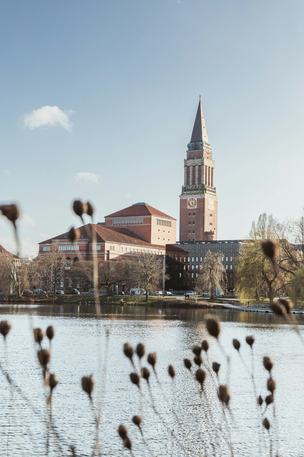 a large building with a clock tower next to a body of water