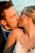A happy couple sharing a kiss on their wedding day, beautifully captured by Ever After Cinema.