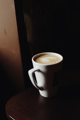 A Loading Coffee Shop ceramic mug filled with latte art, set against a backdrop of Seattle’s urban vibe.