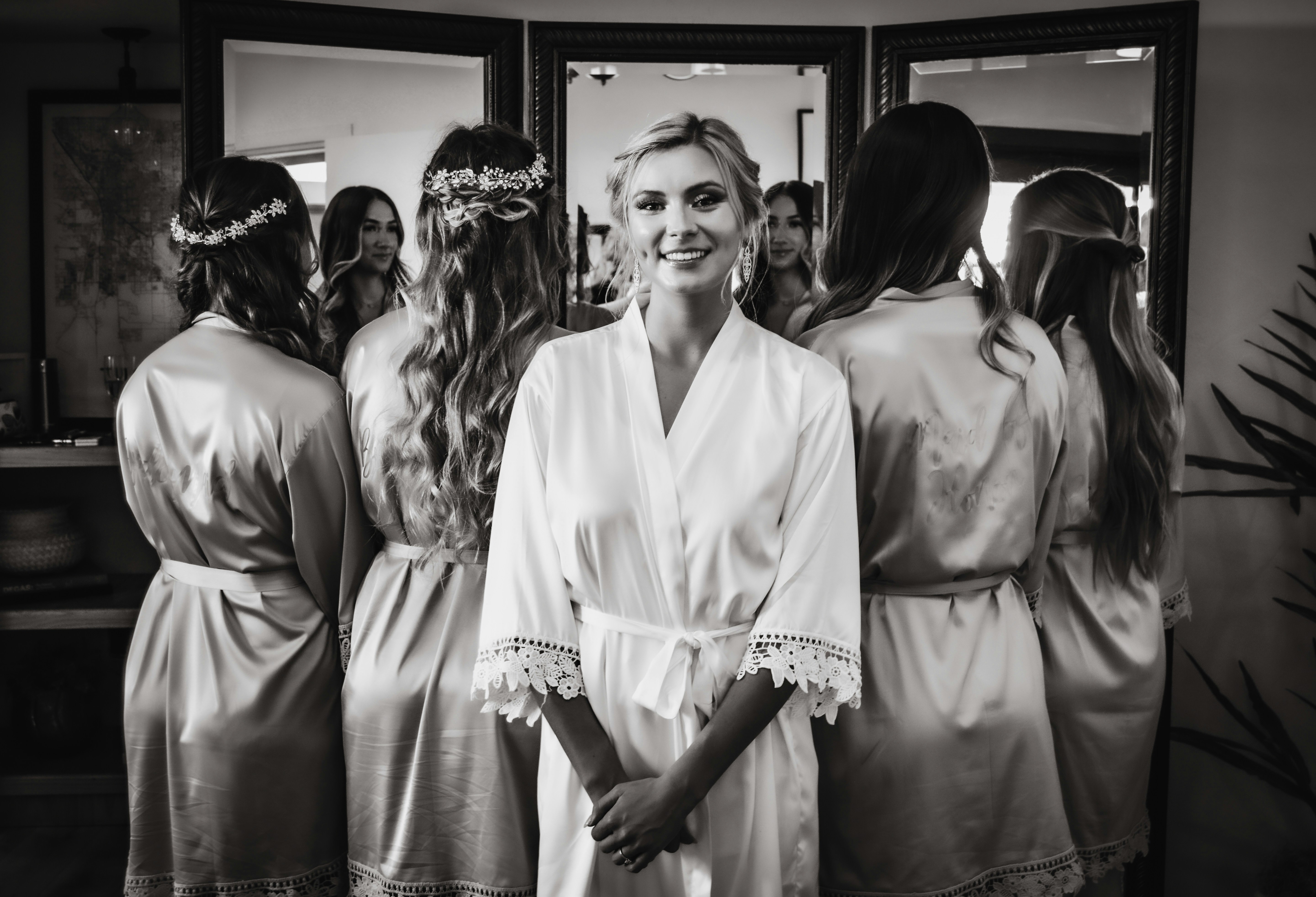 A woman standing in front of a mirror wearing a robe