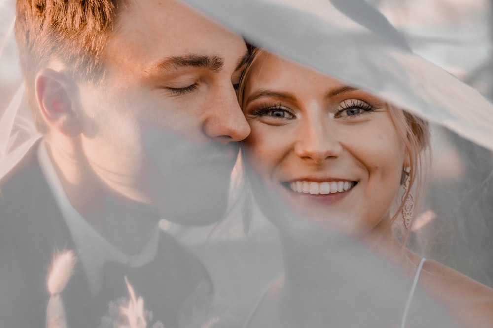 a man and a woman standing under a veil