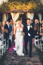 a bride and groom walking down the aisle