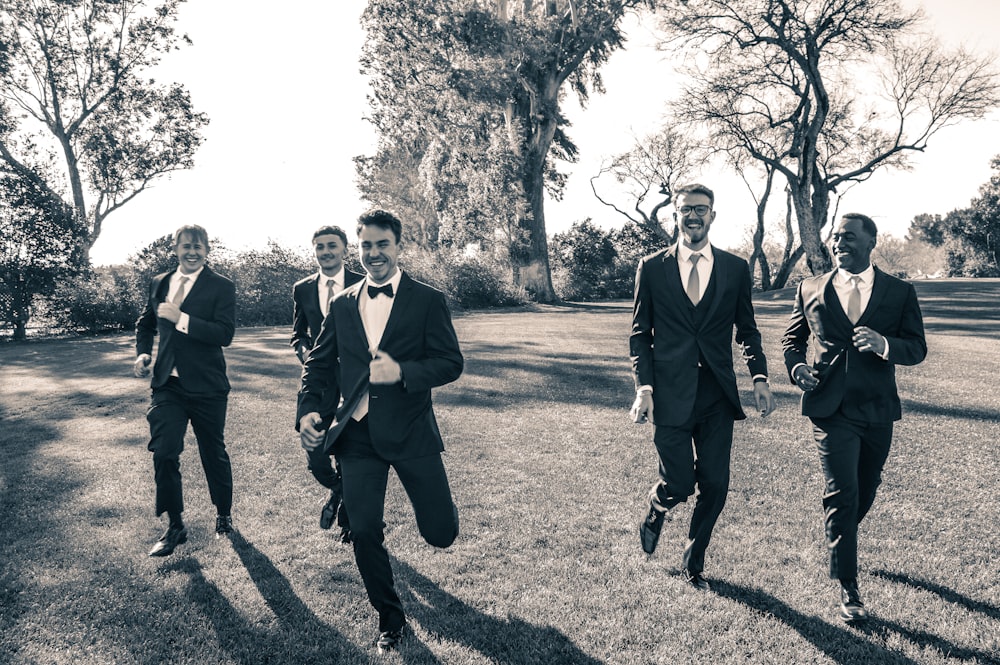 a group of men in suits running across a field