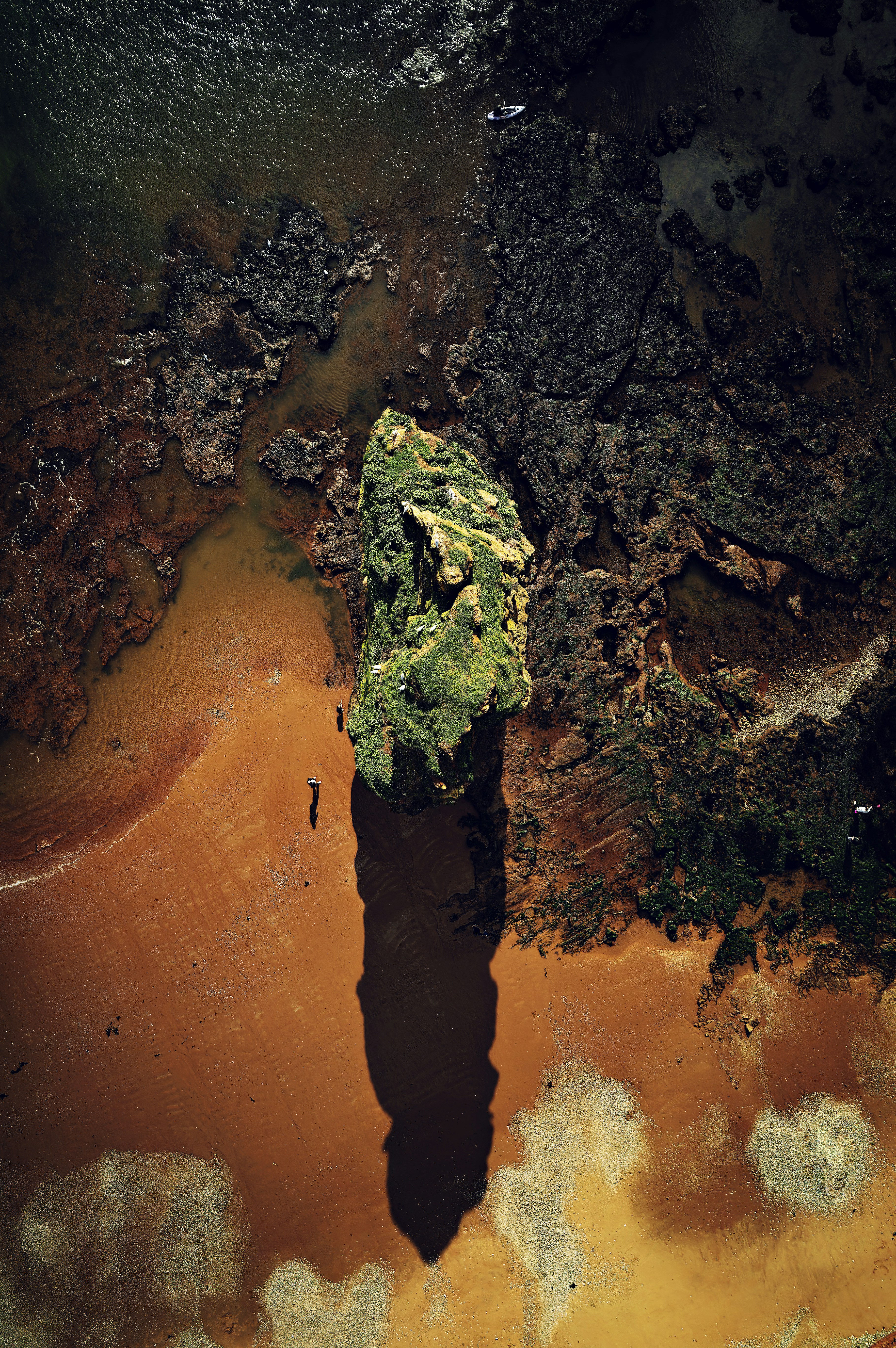 a large rock sitting on top of a sandy beach