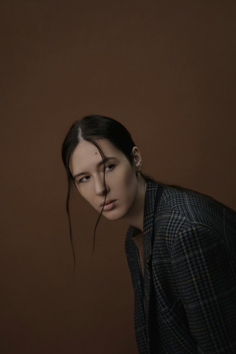 a woman in a black and white jacket and a brown background