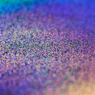 Close-up of a shimmering holographic material glowing softly with vibrant colors.