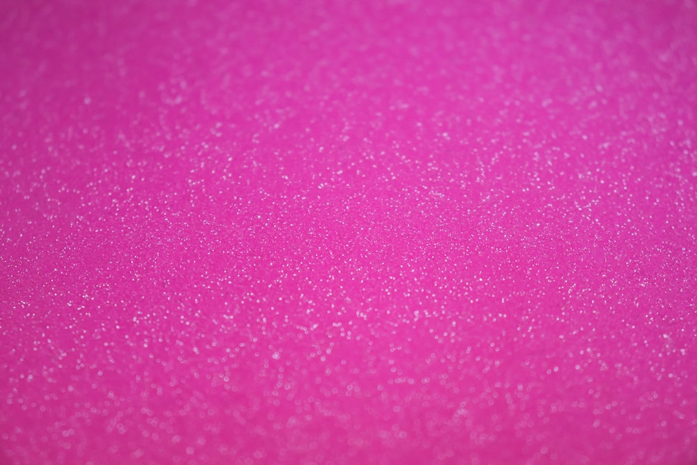 小さな泡のあるピンク色の表面のクローズアップ