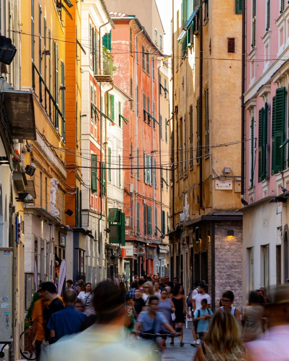 a crowd of people walking down a street next to tall buildings