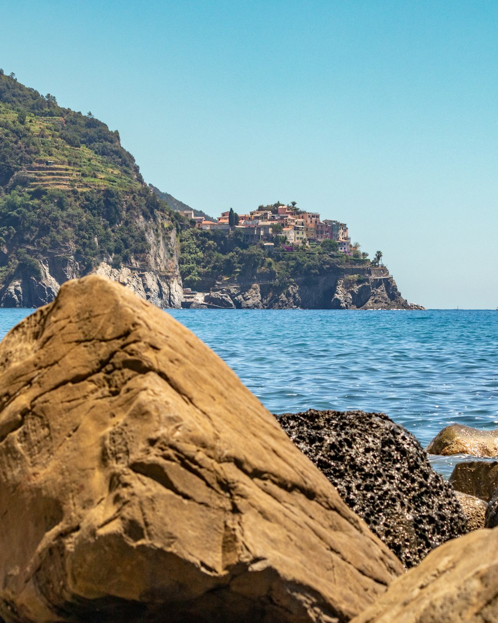 a person sitting on a rock near the ocean