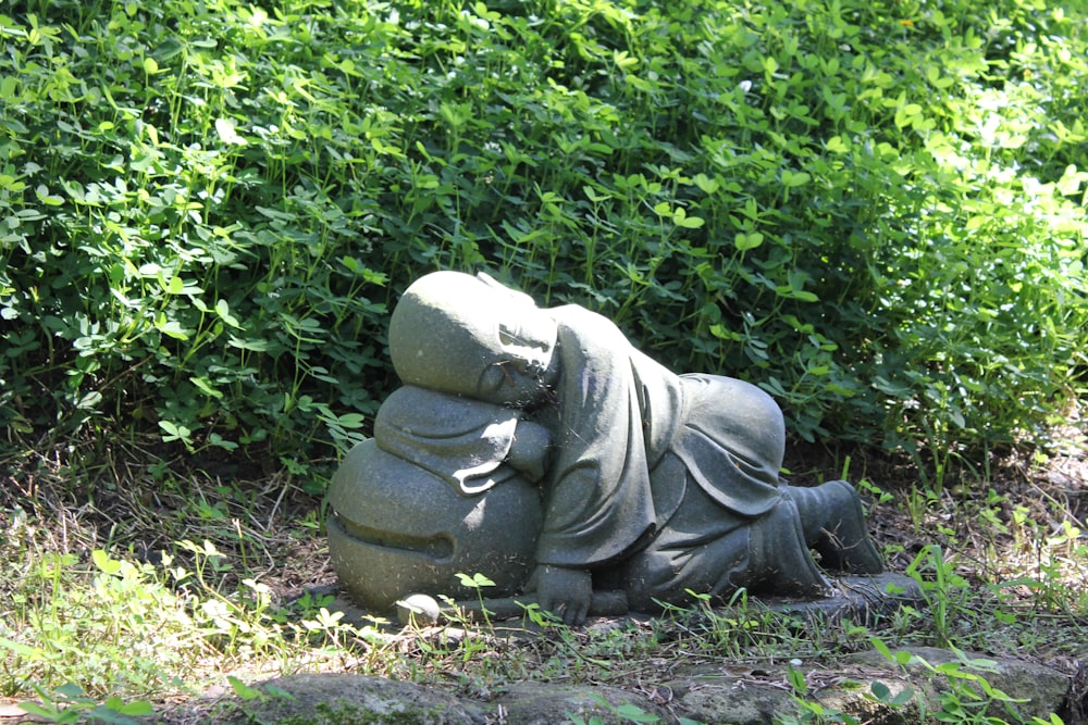 una estatua de una persona acostada encima de un montón de rocas