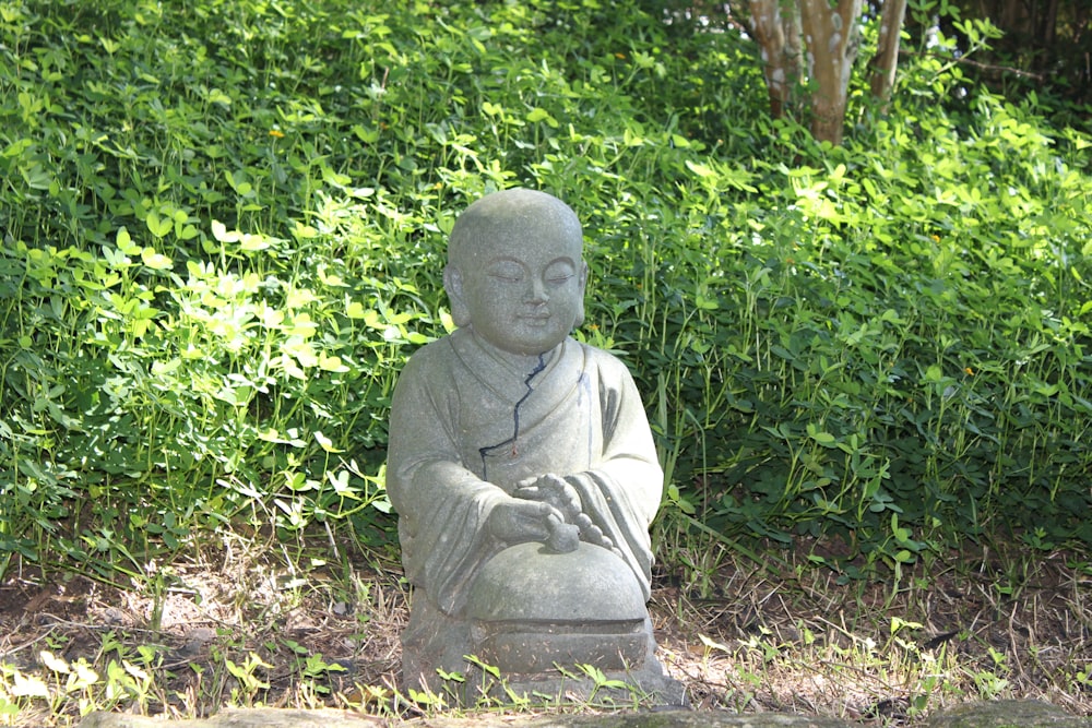 Eine Statue eines Buddha, der im Gras sitzt