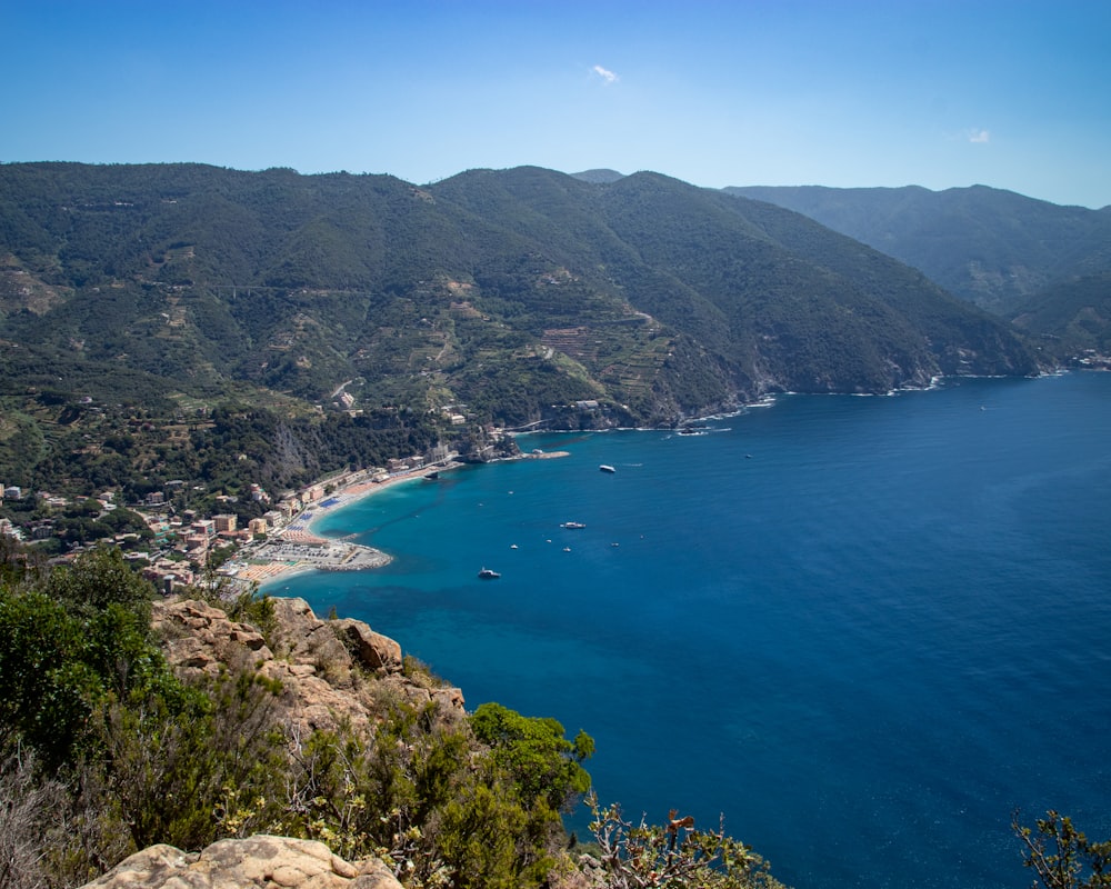 a view of a beach and mountains from a hill