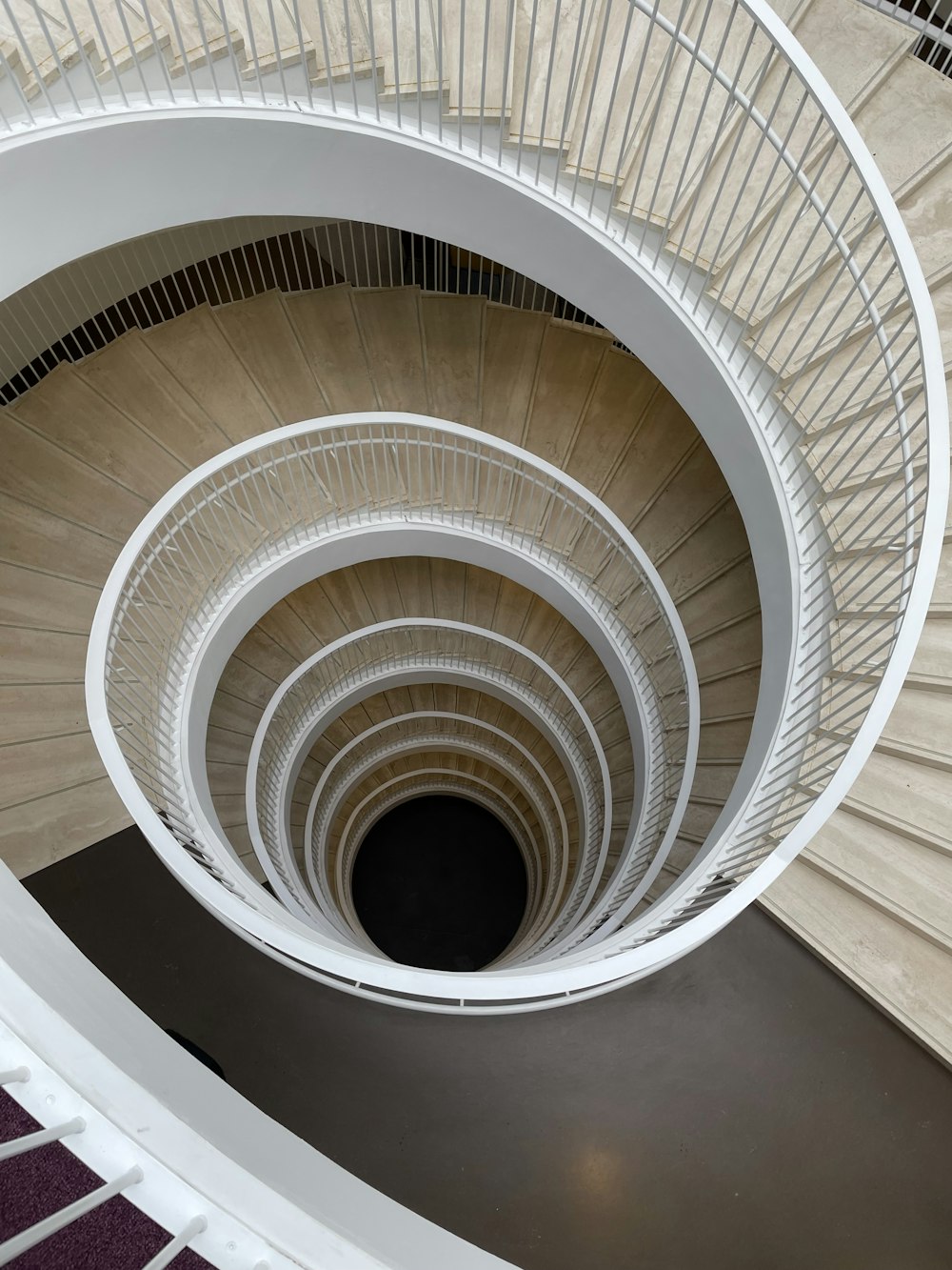 a spiral staircase in a building with white railings