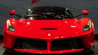 a red sports car on display in a showroom