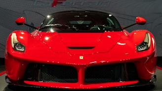 a red sports car on display in a showroom