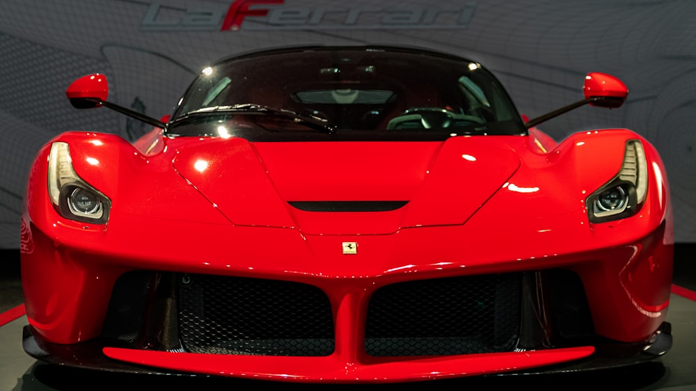 a red sports car on display in a showroom