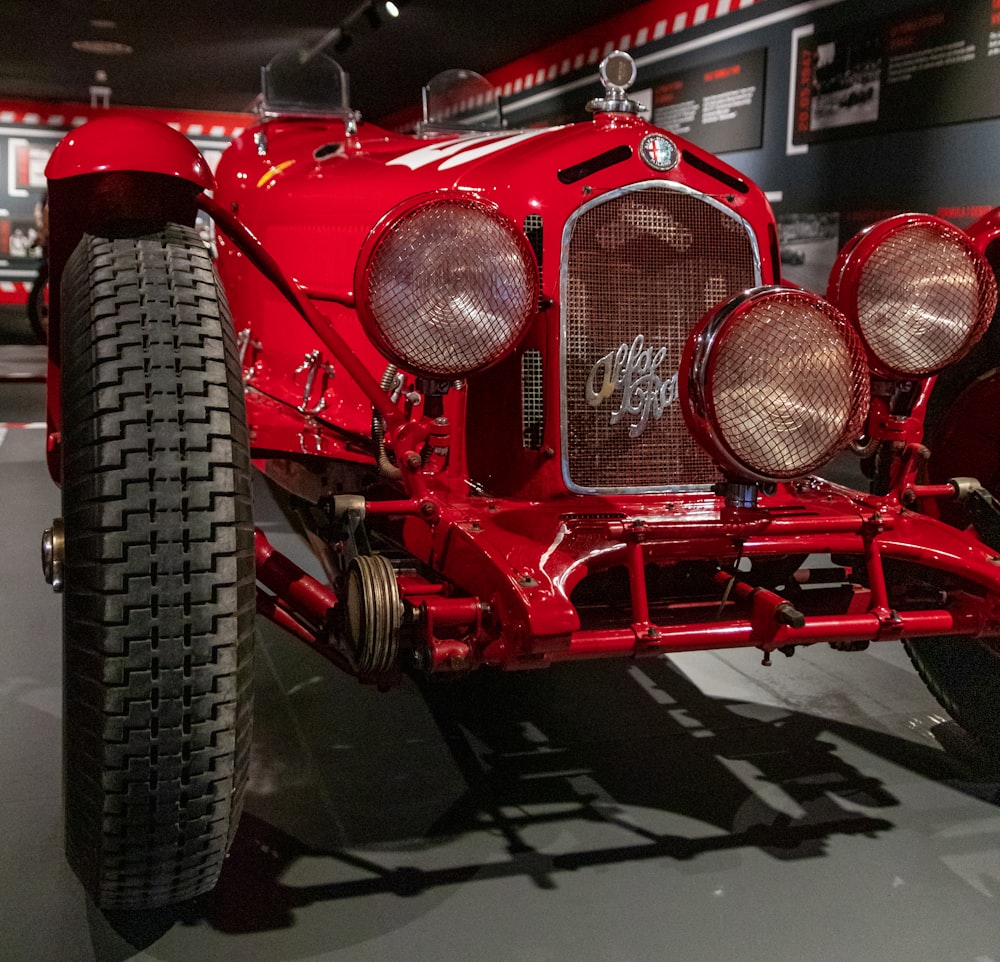 a red car is on display in a museum