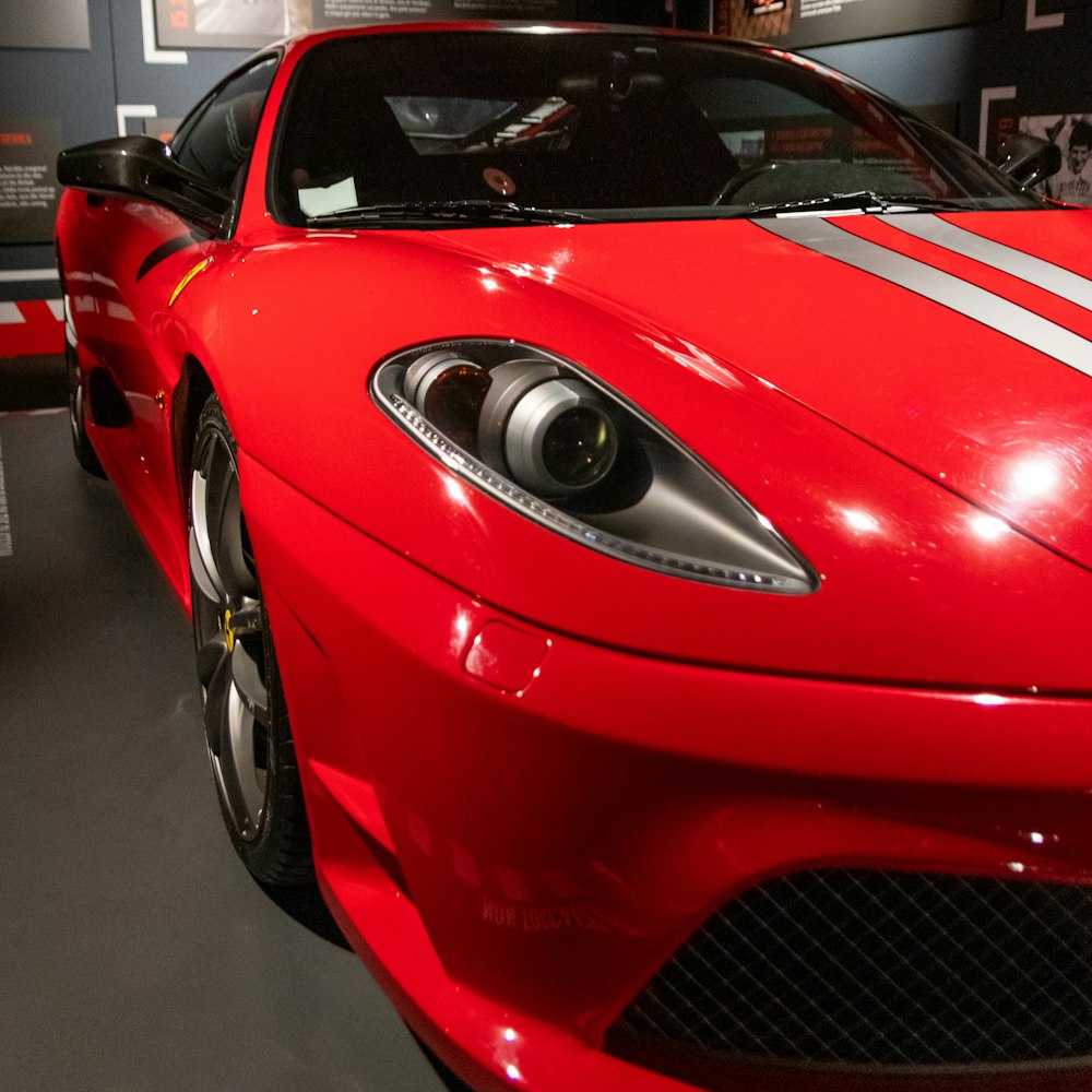 Un auto deportivo rojo está en exhibición en un museo