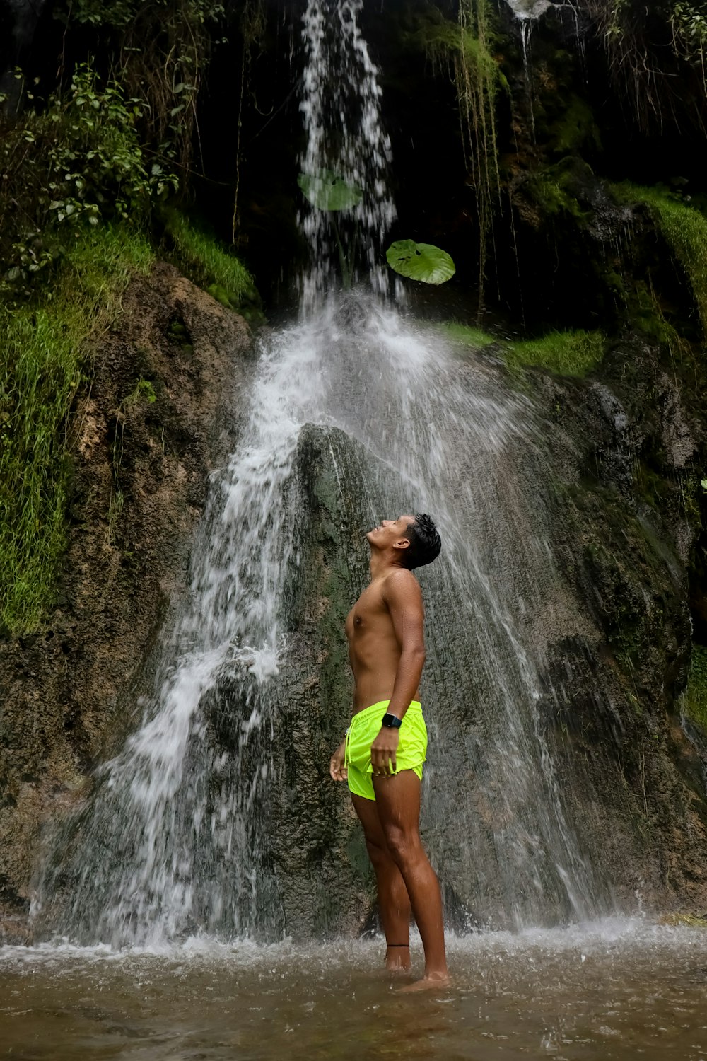 Un hombre parado frente a una cascada