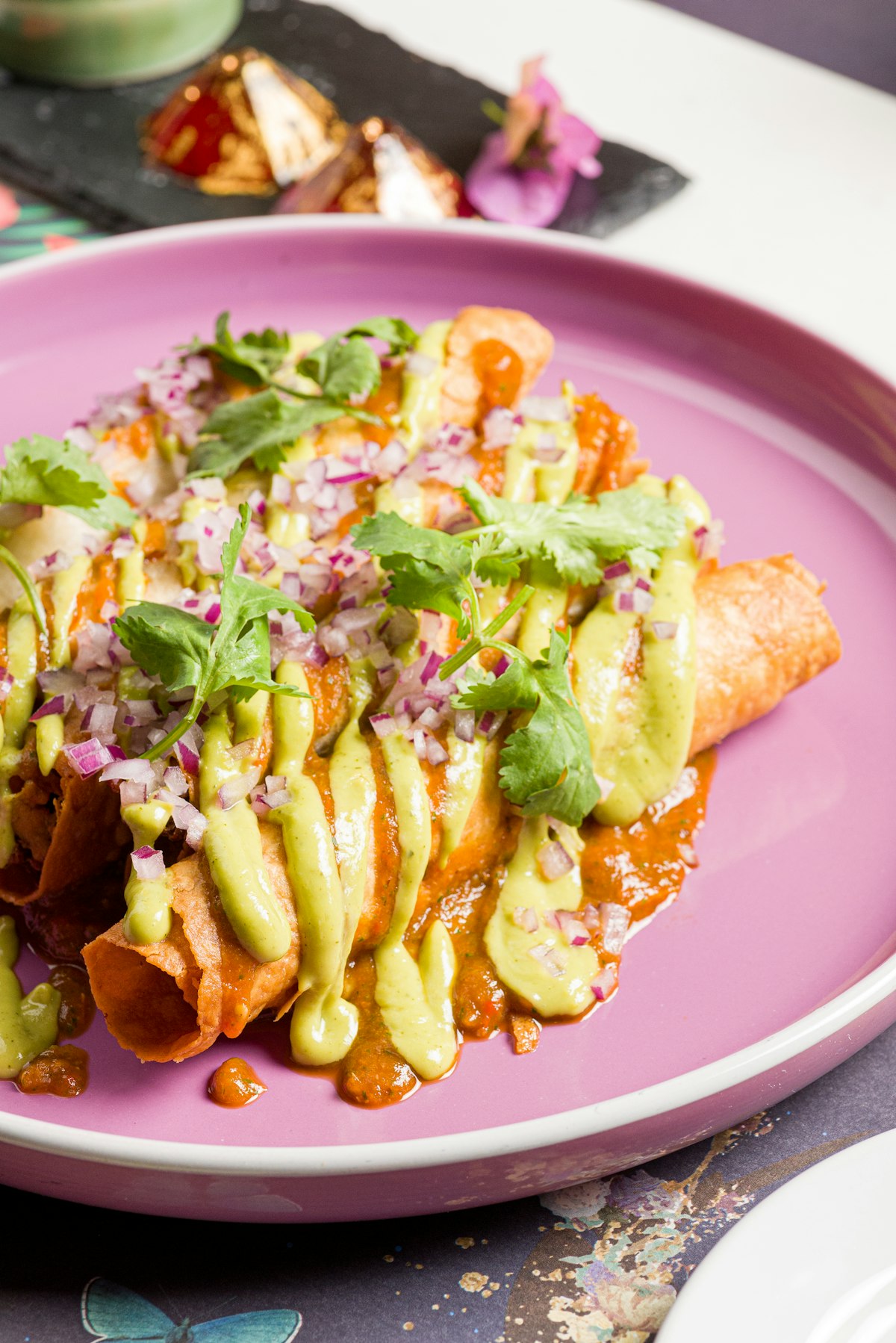 Authentic Mexican beef enchiladas rojas topped with red chile sauce, crumbled queso fresco, and pickled red onions