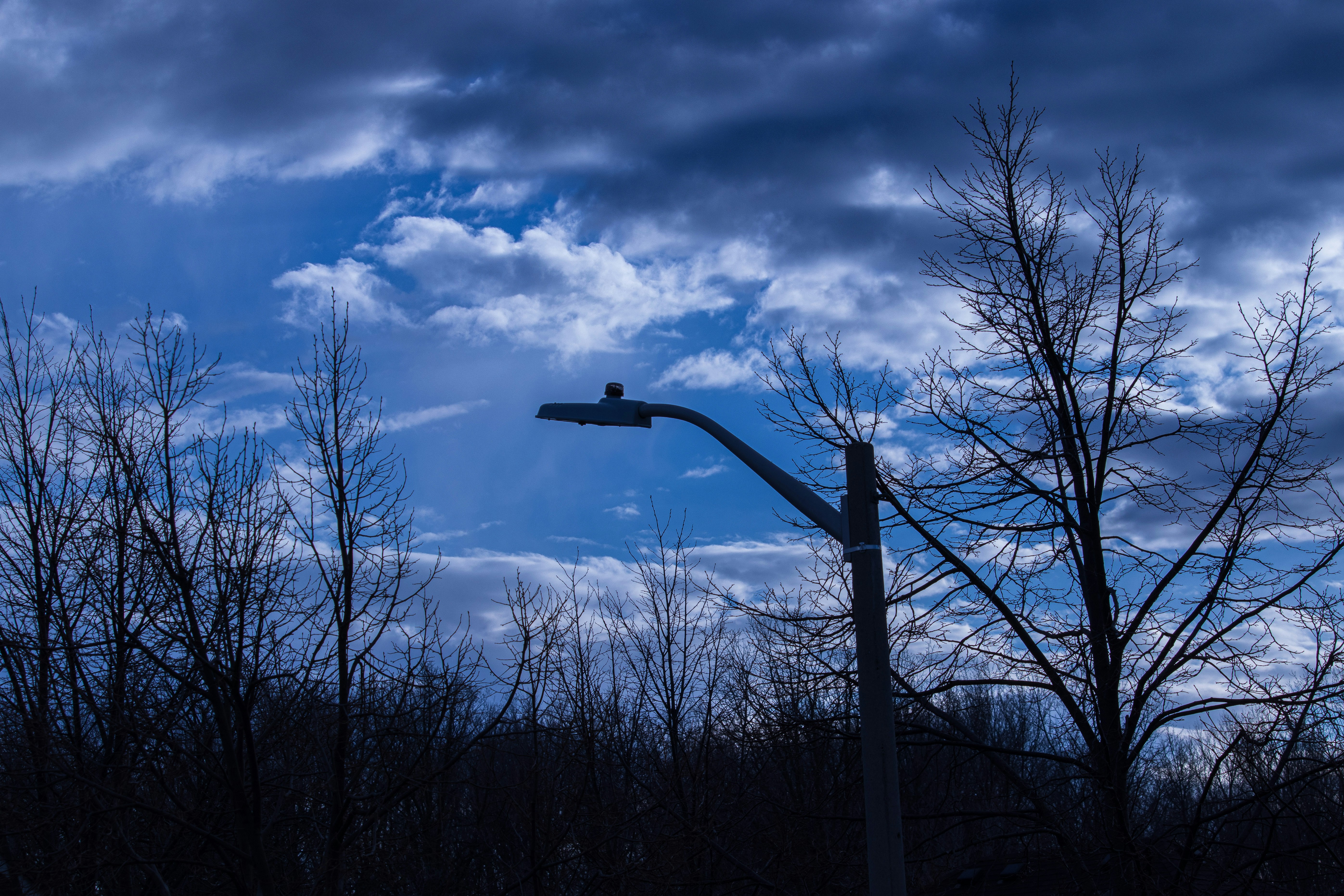 a street light with a cloudy sky in the background