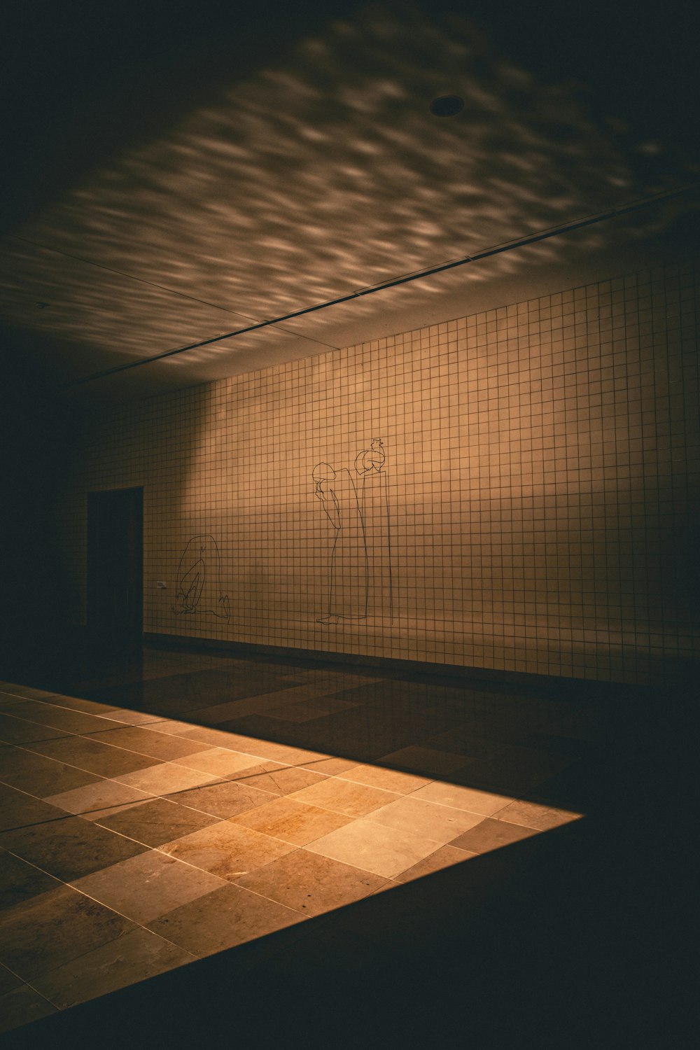 a dimly lit room with a tiled wall