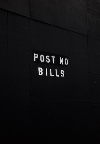 A dark surface features the text 'POST NO BILLS' stenciled in white letters, conveying a clear instruction against placing advertisements or posters.