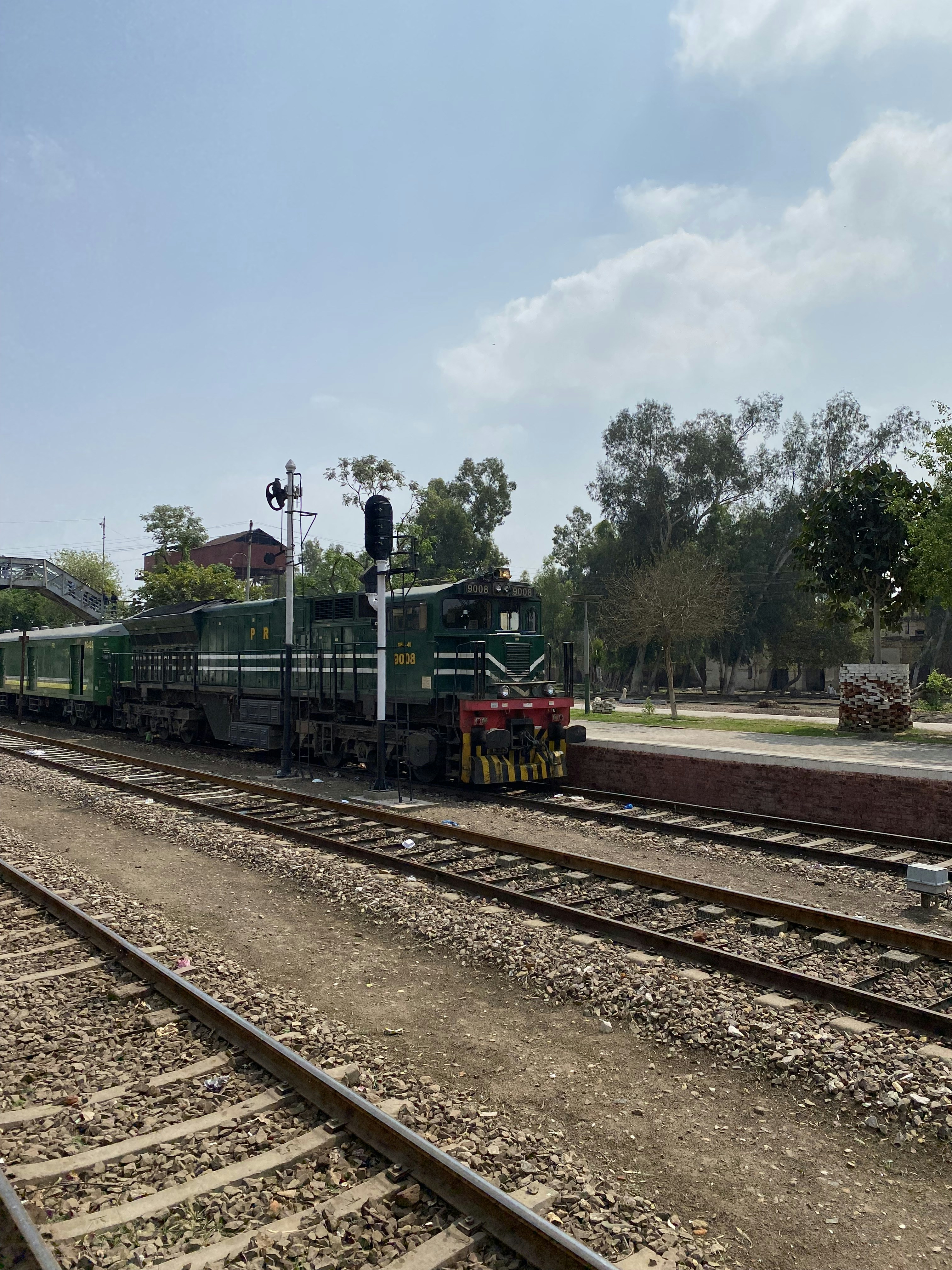 a train traveling down train tracks next to a forest