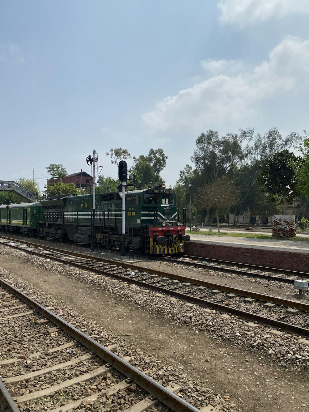 a train traveling down train tracks next to a forest