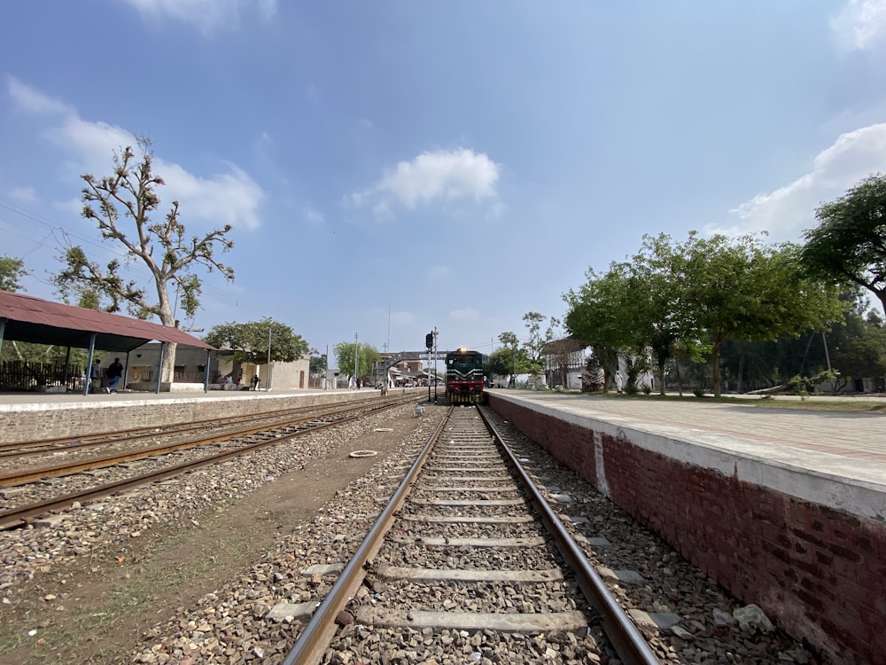 a train traveling down train tracks next to a train station