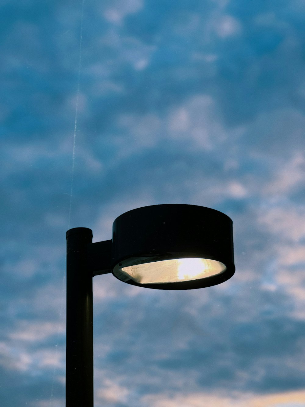 a street light with a cloudy sky in the background