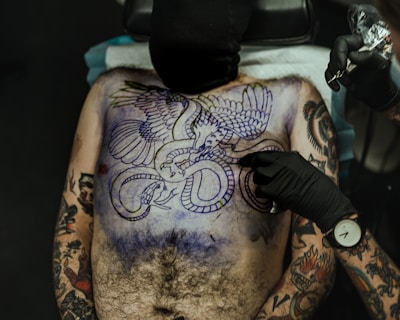 Dynamic tattoo of a phoenix rising with fiery colors on chest.