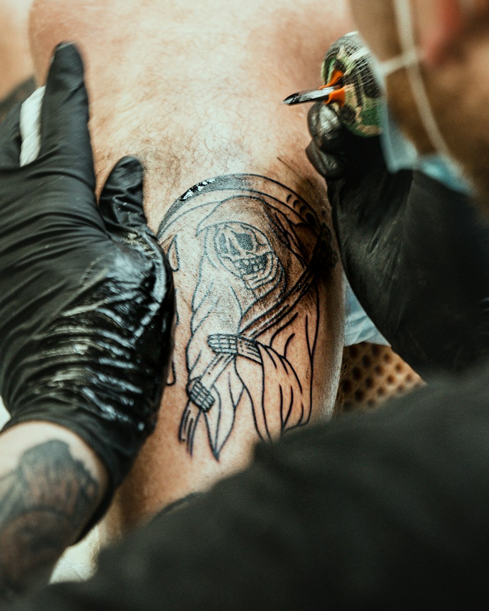 a man getting a tattoo done on his leg