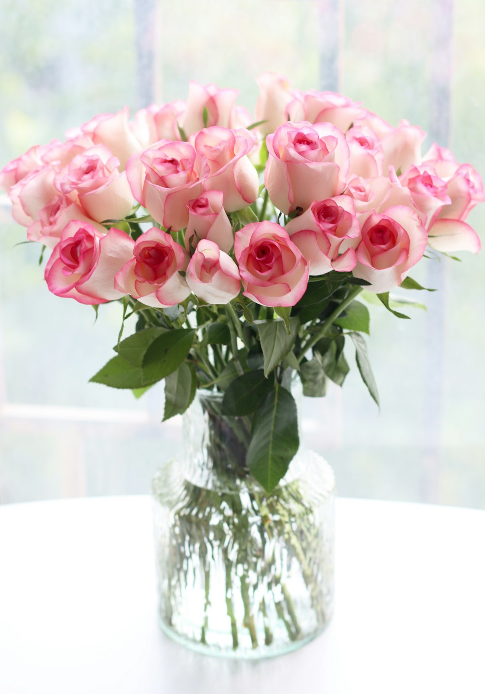 a vase filled with pink roses on a table